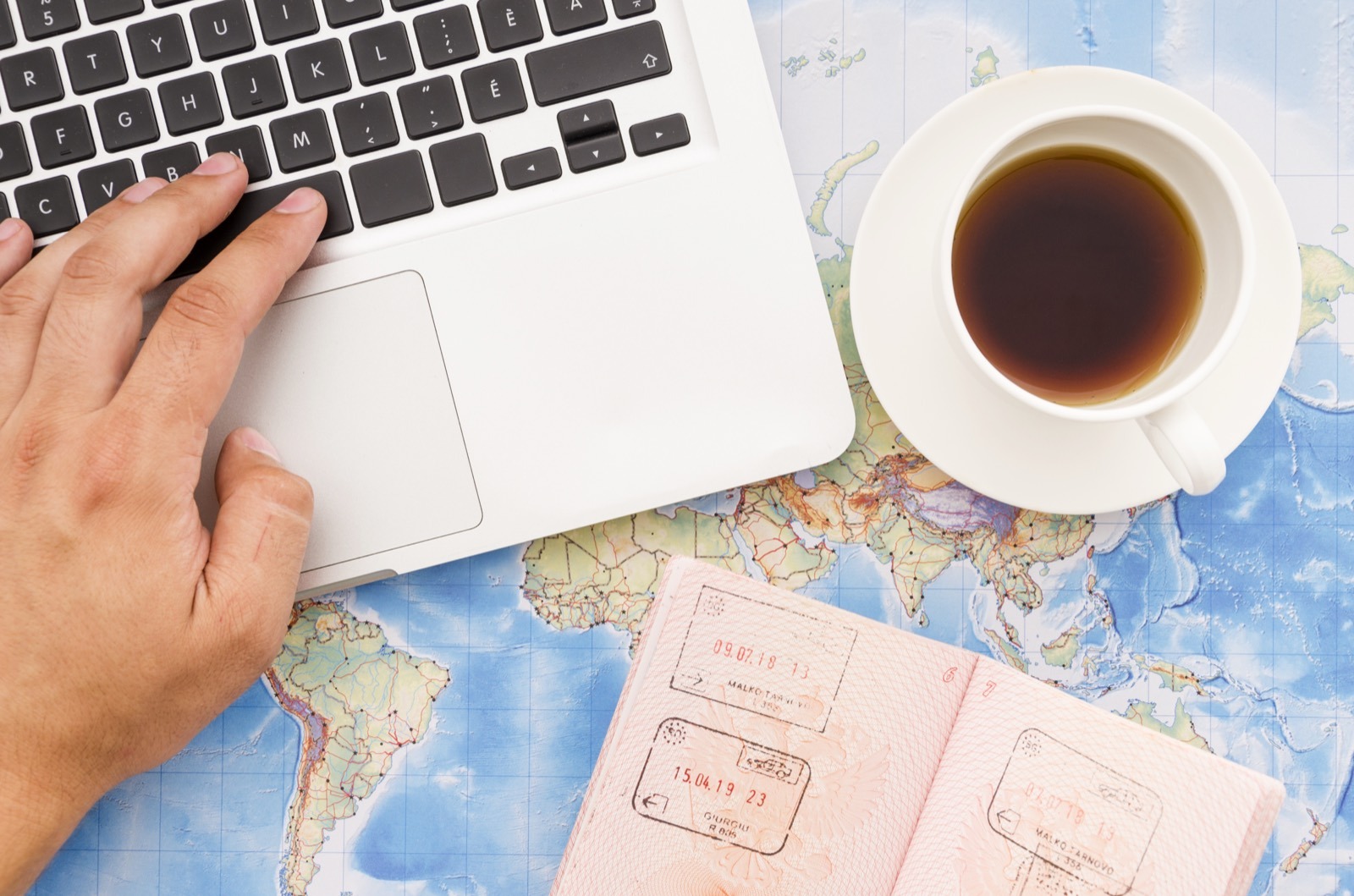 Laptop and passport on a desk while preparing a South African police clearance application from abroad